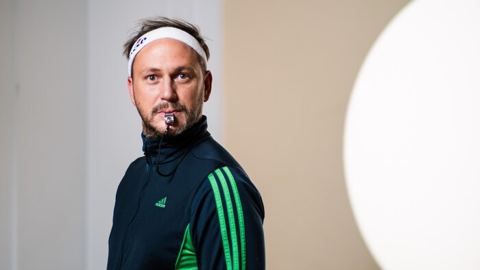 The coach of the soccer academy whistles properly.