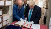 Boris Johnson im Österreichischen Staatsarchiv. Direktor Thomas Just zeigt ihm die Schlussakte ...