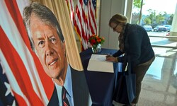 Eine Frau schreibt Worte des Gedenkens in ein Kondolenzbuch für Jimmy Carter.