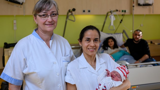 Arman in den Armen von Krankenschwester Ester Souza, mit Kollegin Sylvia Landgraf und dahinter die Eltern Lusine und Harutyun (Bild: Werner Kerschbaummayr/TEAM FOTOKERSCHI / WERNER KERSCHBAUMMAYR)