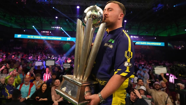 Luke Littler with his World Cup trophy (Bild: Copyright 2025 The Associated Press. All rights reserved)