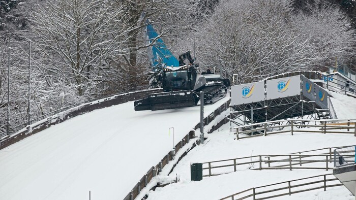 Snow groomers press the snow onto the slope.