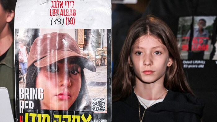 A relative of Liri Albag carries a poster with a picture of the abductees at a demonstration.
