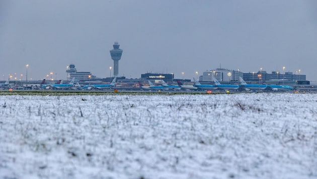 Aircraft stand on the tarmac at Schiphol Airport during a snowfall in Amsterdam on January 5, 2025. The airport warned of delays and cancellations due to the snowfall. (Bild: APA/AFP/ANP/Nickelas Kok)