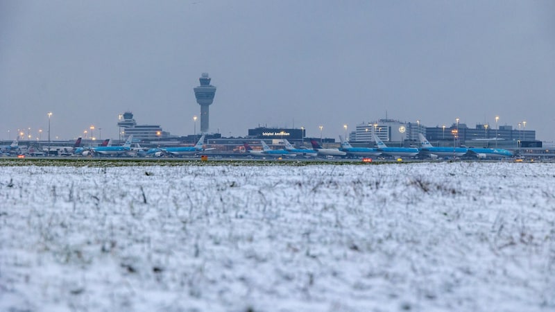 Flugzeuge stehen auf der Rollbahn des Flughafens Schiphol während eines Schneefalls in Amsterdam am 5. Jänner 2025. Der Flughafen warnte vor Verspätungen und Annullierungen aufgrund des Schneefalls. (Bild: APA/AFP/ANP/Nickelas Kok)