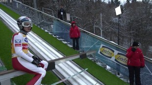 Kopfschütteln und „Tadel“ für den Kollegen: Daniel Tschofenig sorgte für einen Schmunzelmoment vor seinem Trainingssprung. (Bild: Screenshot ORF)