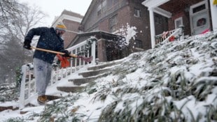 Missouri ist einer der US-Bundesstaaten, in denen der Notstand ausgerufen wurde – im Bild ein Hausbesitzer beim Schneeschaufeln in St. Louis. (Bild: APA/Associated Press)