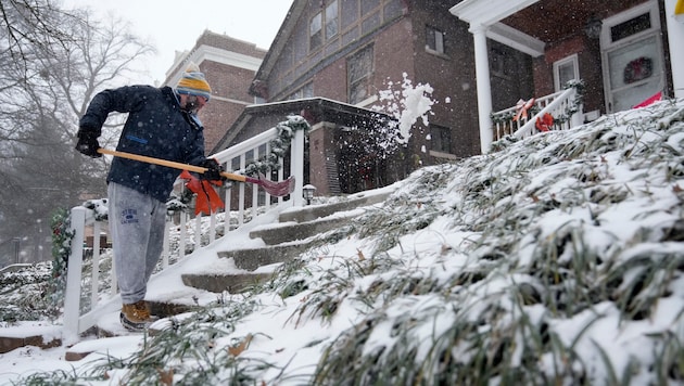 Missouri ist einer der US-Bundesstaaten, in denen der Notstand ausgerufen wurde – im Bild ein Hausbesitzer beim Schneeschaufeln in St. Louis. (Bild: APA/Associated Press)