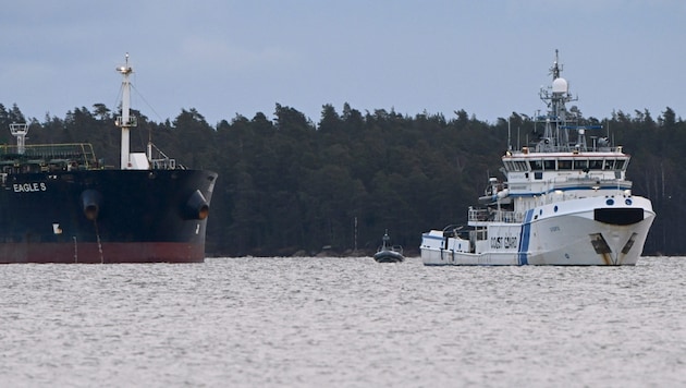 A Finnish Coast Guard vessel (right) stands guard at the Eagle S oil tanker anchored near the port of Kilpilahti in Porvoo on the Gulf of Finland. (Bild: APA/AFP/Lehtikuva/Jussi Nukari)