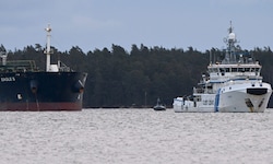 Ein Schiff der finnischen Küstenwache (rechts) hält Wache am Öltanker Eagle S, der in der Nähe ...