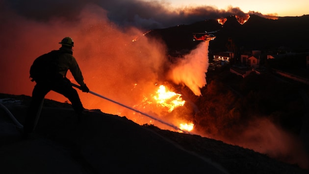 A firefighter battles the flames. (Bild: AFP/DAVID SWANSON)