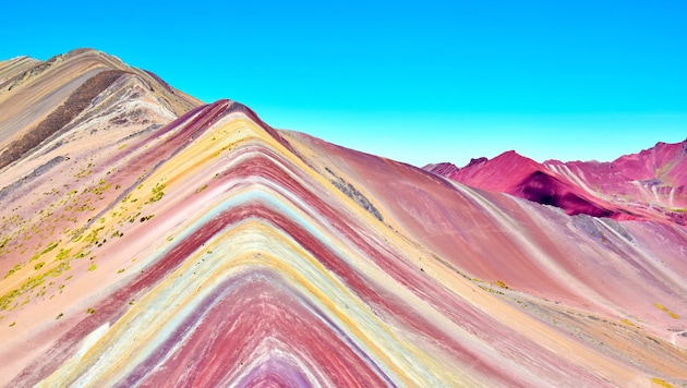 Der Regenbogenberg von Vinicunca südlich von Cusco erlangte seine sieben Farben aufgrund von Mineralstoffen wie Eisen oder Magnesium. Sie haben sich über Millionen von Jahren angesammelt und geben heute ein buntes Bild ab, das seinesgleichen sucht. (Bild: stock.adobe.com/alessandro - stock.adobe.com)