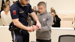 Der angeklagte Serbe wird im Wiener Landesgericht in Handschellen vorgeführt.