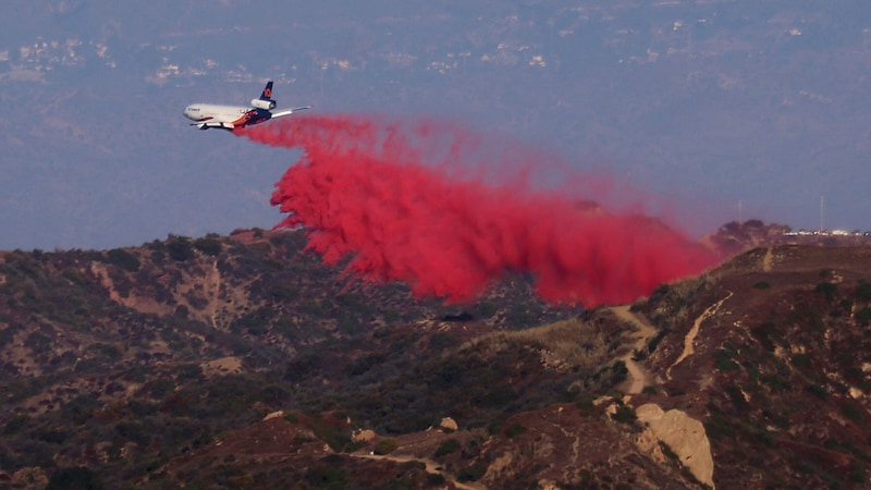 Dieses Flugzeug versprüht Flammschutzmittel, damit sich die Flammen nicht weiter ausbreiten. (Bild: APA/AFP/David Swanson)