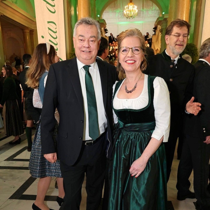 Werner Kogler in a black suit and Leonore Gewessler in a traditional costume by Gexi Tostmann