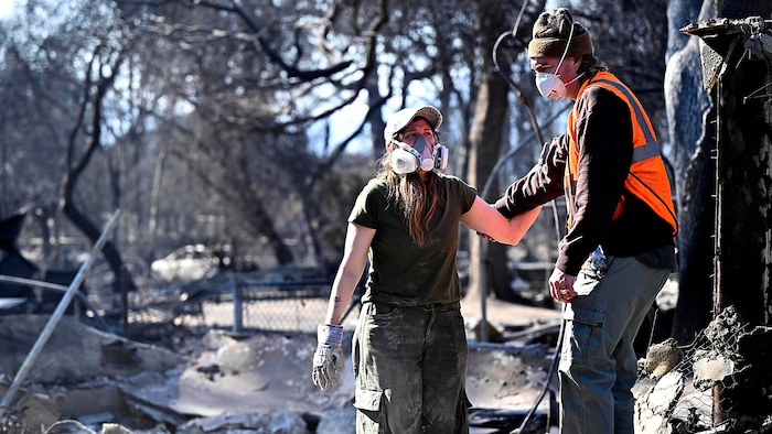 A couple inspect the ruins of their house in Altadena.