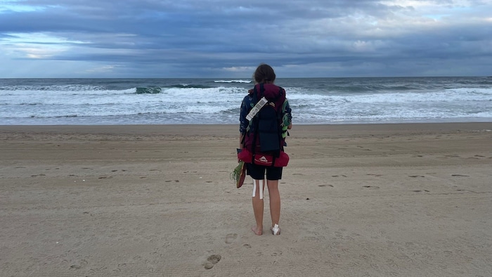 Rita M. an einem Strand in Spanien. Da hatte sie das Zelt noch im Gepäck (unten am Rucksack ...