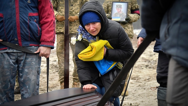 Relatives and comrades mourn the loss of a fallen Ukrainian soldier. How many more sons, brothers, husbands and fathers will die before the guns fall silent? (Bild: APA/AP)