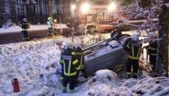 Das Auto lag am Dach im Schnee  (Bild: FF Bad Ischl)