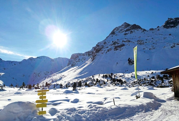 Die Lizumer Sonnenspitze (hinter der Fahne) ragt südlich der Hütte empor.
