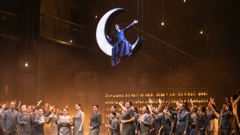 In women's clothes in the gentlemen's club: Sarastro (Georg Zeppenfeld) mocks the Queen of the Night while floating on a crescent moon. (Bild: (c) Wiener Staatsoper, Sofia Vargaiova)