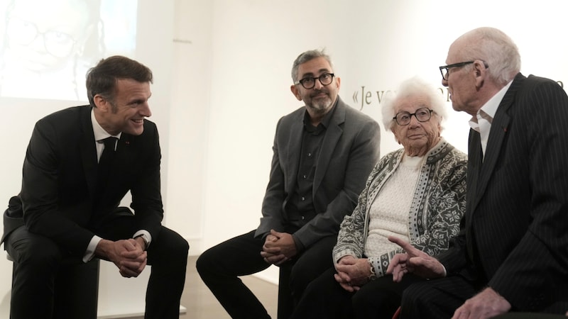 Macron in conversation with two survivors (Bild: AP/Thibault Camus)