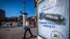 Ungarns Regierung macht auch laufend mit Werbeplakaten darauf aufmerksam, dass die Sanktionen „uns ruinieren“. Doch nun stimmte Budapest einer Verlängerung der Maßnahmen gegen Russland zu. (Bild: AFP/FERENC ISZA)