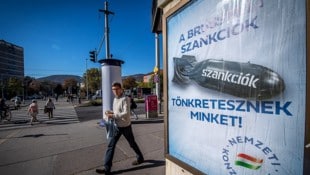 Ungarns Regierung macht auch laufend mit Werbeplakaten darauf aufmerksam, dass die Sanktionen „uns ruinieren“. Doch nun stimmte Budapest einer Verlängerung der Maßnahmen gegen Russland zu. (Bild: APA Österreich Bild/AFP/FERENC ISZA)