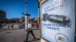 Ungarns Regierung macht auch laufend mit Werbeplakaten darauf aufmerksam, dass die Sanktionen „uns ruinieren“. Doch nun stimmte Budapest einer Verlängerung der Maßnahmen gegen Russland zu. (Bild: AFP/FERENC ISZA)