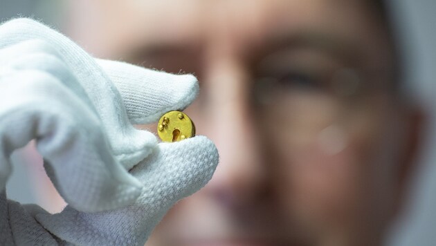 Michael M. Rind, Director of LWL Archaeology for Westphalia, holds the archaeological find of a miniature Roman box lock between his fingers. (Bild: APA/dpa/Guido Kirchner)