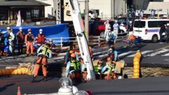 In Japan hat ein riesiges Loch einen Lastwagen samt Fahrer verschluckt. (Bild: JIJI Press/STR)