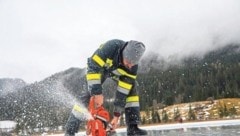 Mittels Motorsägen retten die Feuerwehren die Eislauffläche des Weißensees.  (Bild: FF Weißensee)