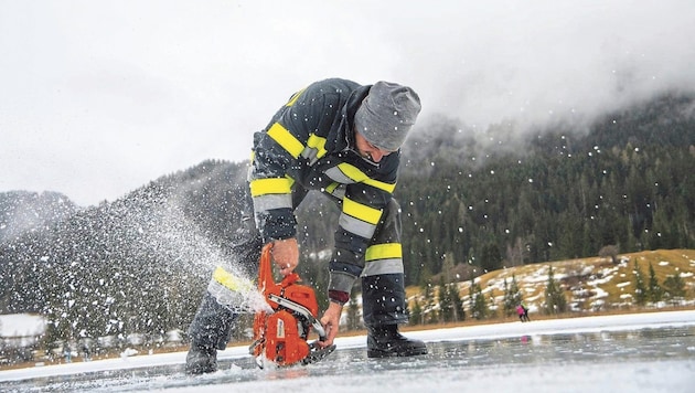 The fire departments use chainsaws to clear the ice rink on Lake Weissensee. (Bild: FF Weißensee)