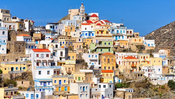 The colorful little houses of Olympos nestle tightly against the rocky slope.