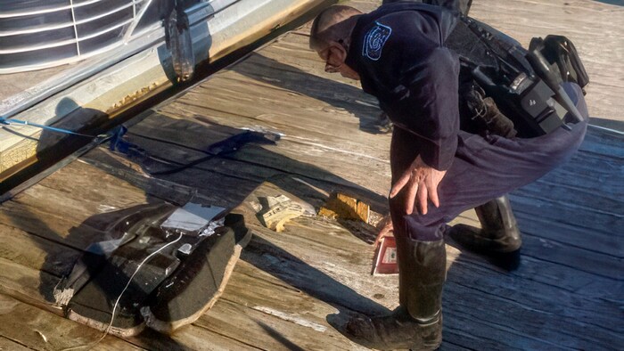 Ein Polizeibeamter begutachtet die Trümmer, die aus dem Potomac River geborgen wurden.