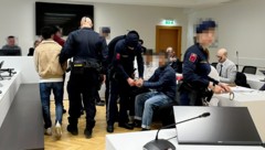 Die jungen Angeklagten werden umringt von Justizwachebeamten vorgeführt. (Bild: Sophie Pratschner, Krone KREATIV)