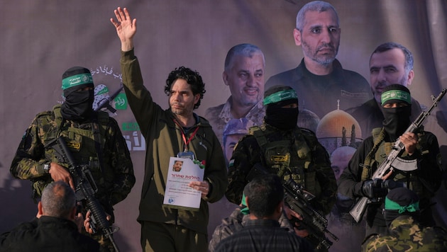 Hamas with a released Israeli hostage (Bild: AP)