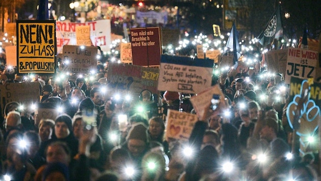 Participants hold up lights and signs on the street in front of the CDU party headquarters during a demonstration under the slogan "Uprising of the decent - demo for the firewall". (Bild: APA/dpa/Sebastian Gollnow)