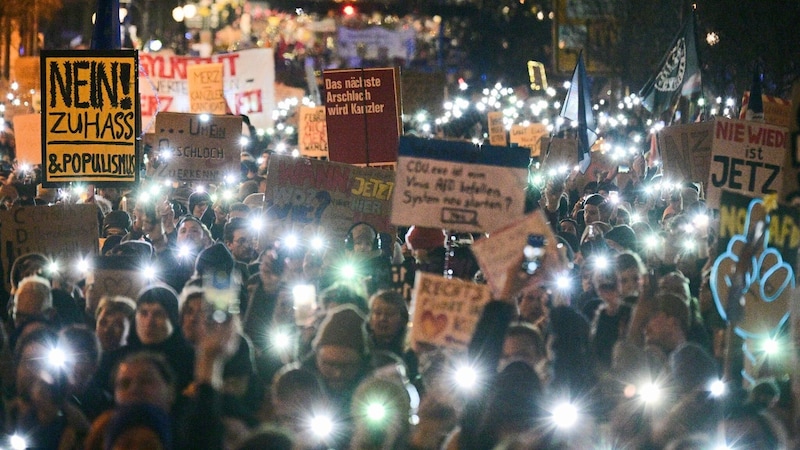 Teilnehmer halten während einer Demonstration unter dem Motto „Aufstand der Anständigen – Demo für die Brandmauer“ auf der Straße vor der CDU-Parteizentrale Lichter und Schilder hoch. (Bild: APA/dpa/Sebastian Gollnow)