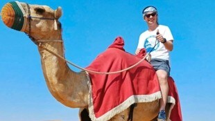 Superfan Gernot Thierschädl beim Kamelritt in Dubai am Weg nach Almaty.
