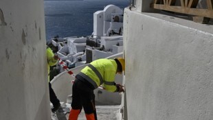 Arbeiter sperren in Santorin einen Weg für Touristen ab.