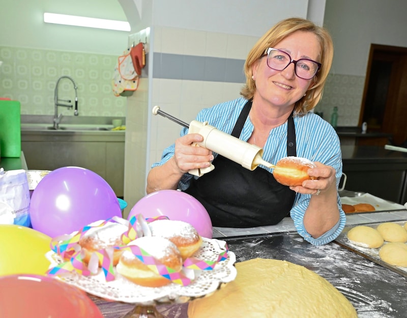 The friendly senior chef Marlies Ruhdorfer has the dipping syringe ready to fill the countless doughnuts - with apricot jam, of course. (Bild: Evelyn Hronek)