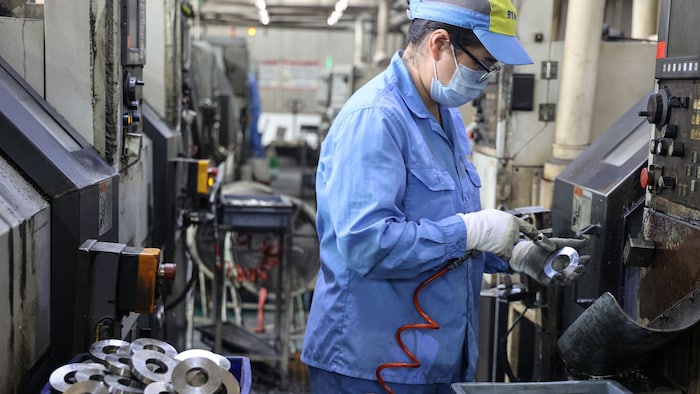 Ein Arbeiter stellt Produkte aus Aluminium in einer Fabrik in China her.