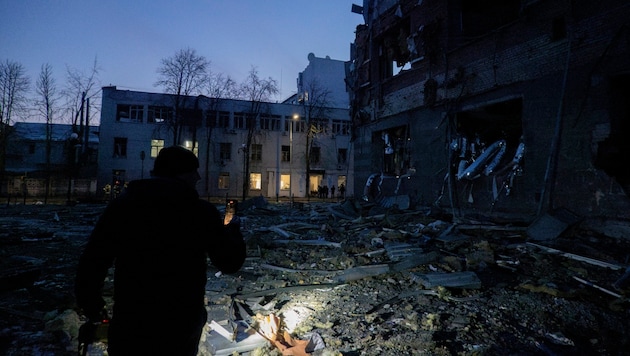 A police officer takes a picture of the consequences of the Russian attack. (Bild: ASSOCIATED PRESS)