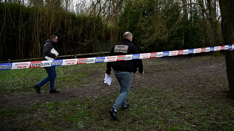 Police officers at the site where the body of the eleven-year-old victim was found. (Bild: APA/AFP )