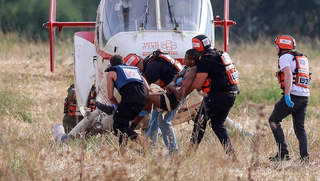 Rettungskräfte beim Bergen eines Terroropfers (Bild: APA/AFP/Menahem KAHANA)