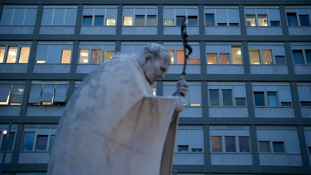 Eine Marmorstatue des verstorbenen Papstes Johannes Paul II. vor der Poliklinik Agostino Gemelli in Rom, wo Papst Franziskus behandelt wird. (Bild: AP)