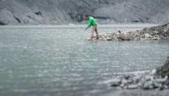 Ein Greenpeace-Mitarbeiter nimmt an der Pasterze am Fuße des Großglockners eine Wasserprobe – Gletscherseen sind leider mit Plastikpartikel belastet, wie sich zeigt.  (Bild: Greenpeace/Mitja Kobal)