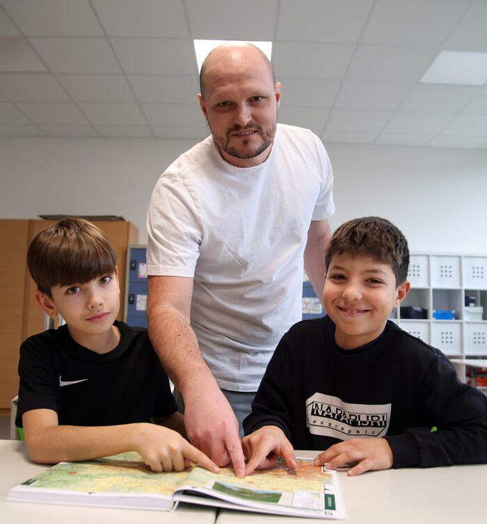 Secondary school teacher Urbanek shows where Weißkirchen is located in the atlas.