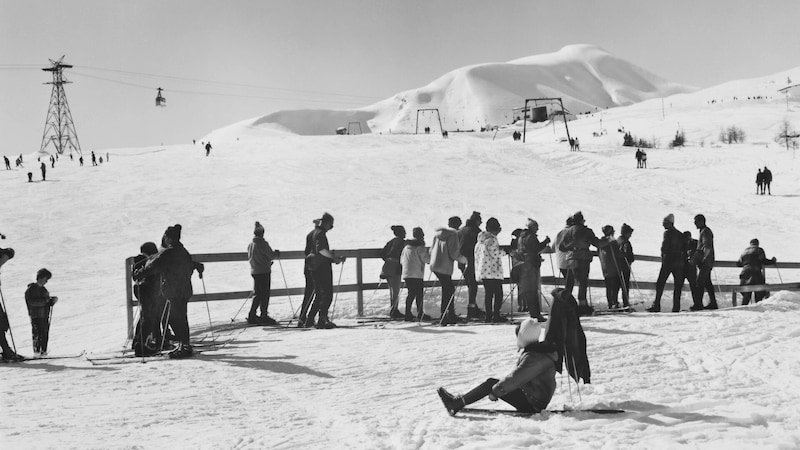 While some skiers queue in front of the Gampen T-bar lift, others use their break to sunbathe. (Bild: Archiv Praxmarer)